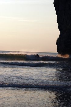 lone surfer beside the cliffs