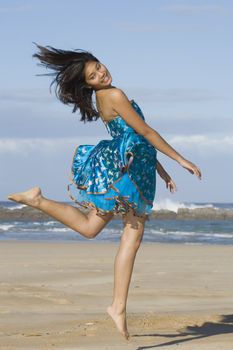 Girl in asian inspired dress jumping into the air