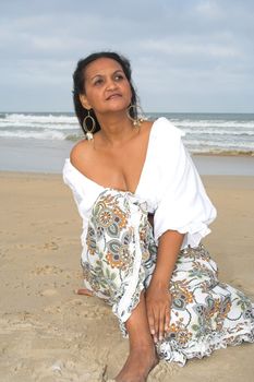 An African American woman sitting at the beach