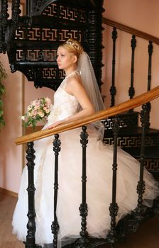 The beautiful bride with a bouquet in an interior