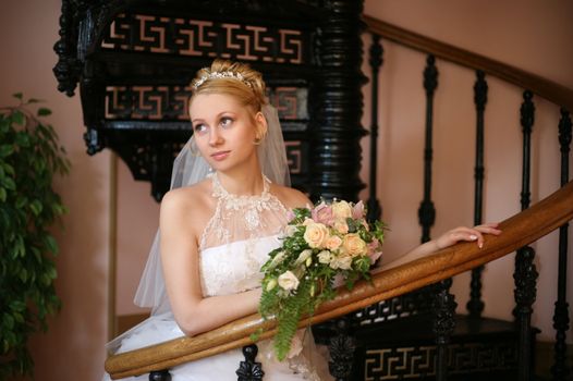 The beautiful bride with a bouquet in an interior
