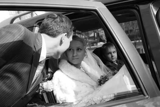 The bride with the little boy in the machine and seeing off groom. b/w