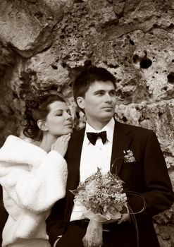 Recently married pair on a background of a stone. b/w+sepia