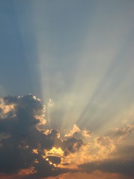 Sun-rays through the clouds in the sky at sunset