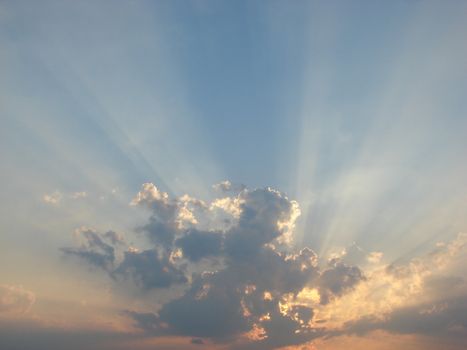 Sun-rays through the clouds in the sky at sunset