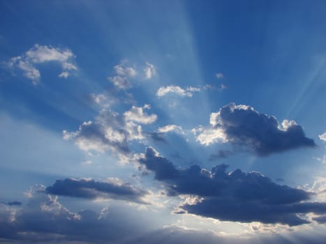 Sun-rays through the clouds in the sky at sunset