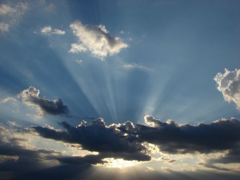 Sun-rays through the clouds in the sky at sunset