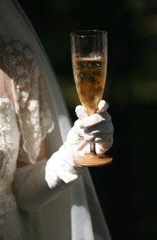 Glass of champagne in a hand of the bride