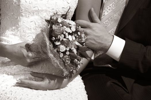 Wedding bouquet in hands of the bride. b/w+sepia