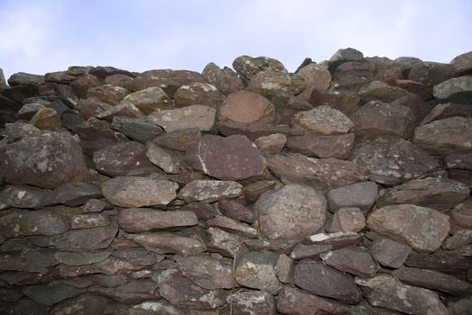 an old irish dry stone wall against a sky background