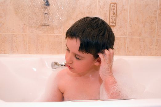 face of a boy in a bathroom close up washing his hair