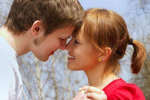 Faces of a young man and a girl close to each other, their noses touch               