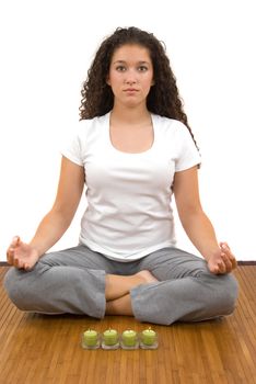 Girl meditating, fragrant candles helping her to relax