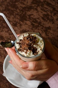 Closeup of female hands holding cup of latte