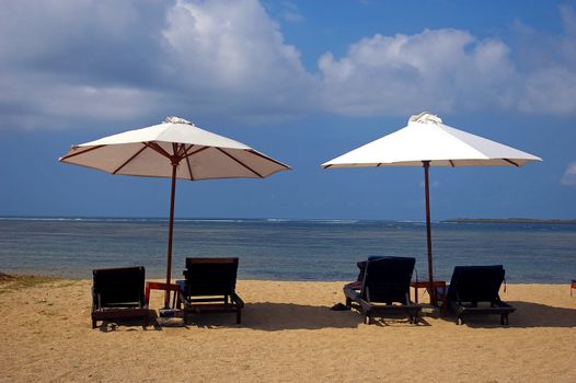 Sunbeds and umbrellas at low season on the beach, Sanur, Bali, Indonesia.