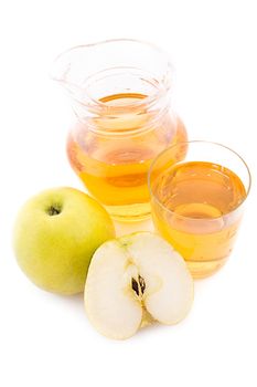 Jug and glass of apple juice over white