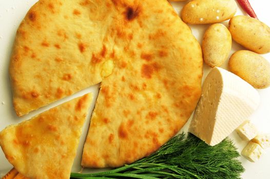 food composition made of flat cake, potato, cheese and spring onion