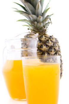 Jug and glass of pineapple juice over white