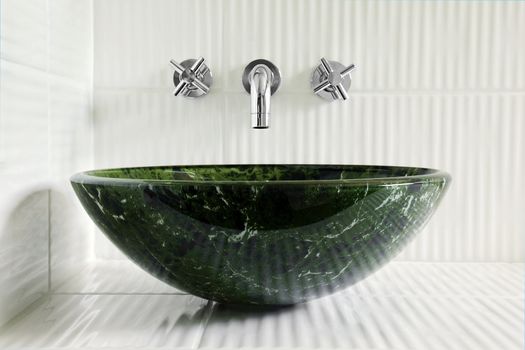 Modern style greean marble vessel sink with wall mount faucets on bright white corrugated tiles.