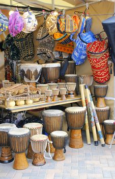 African merchant stand with djembe drums, textile and other traditional arts and crafts.