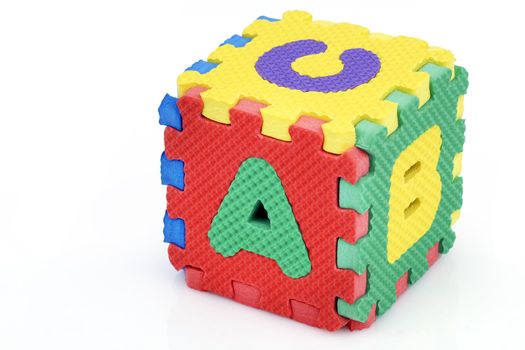Fun colorful toy puzzle cube or dice in textured foam for kids to learn their alphabet, here a, b, c.