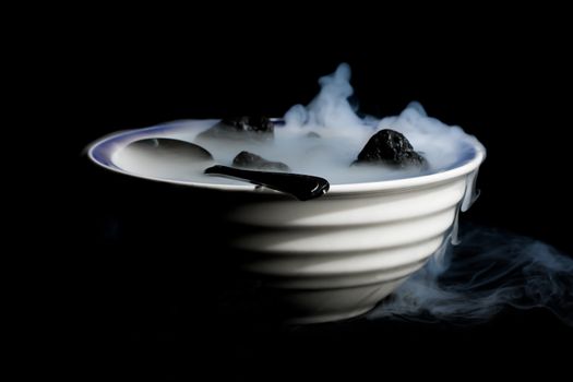 A Smoking bowl of lava rocks and spoon.