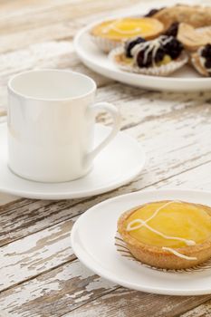 lemon mini tart and espresso coffee on a rustic wooden table