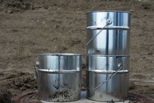 metal silver cans on ground on a building site