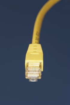 Yellow network cable against blue sky background