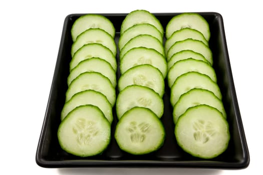 Picture of some sliced cucumbers on  a black plate