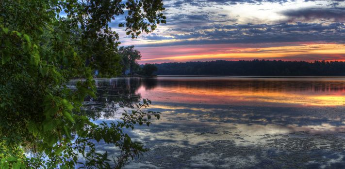 Panorama of a beautiful sunrise on a lake.