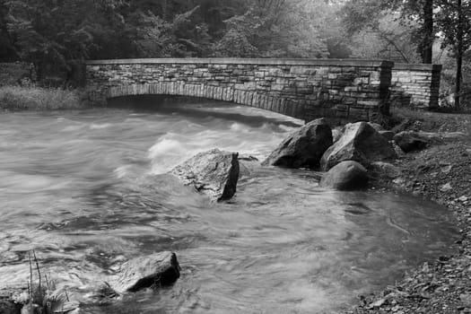 Black and white rendition of a Creek and Bridge.