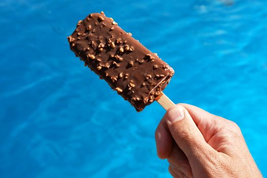 popsicle against a swimming pool on a hot day