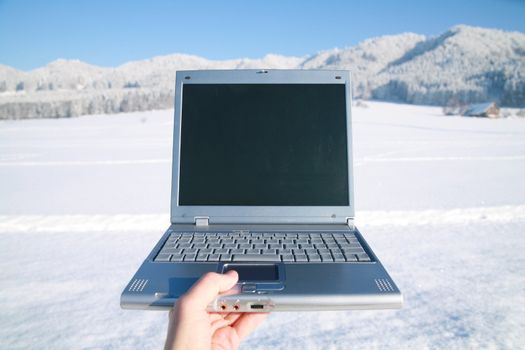 Laptop in a snowy winter landscape scene