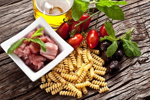 Italian Fusilli pasta with swordfish, olive and raw tomato ingredients