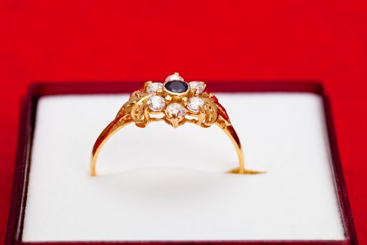 Fantastic gold ring adorned with one blue  and several white zirconia
