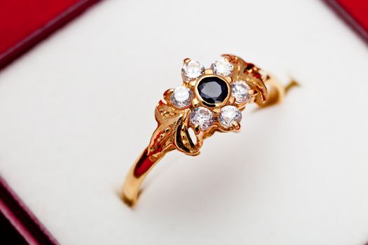Fantastic gold ring adorned with one blue  and several white zirconia