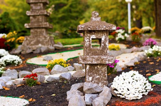 Park in Japanese style with stone objects and flowers.