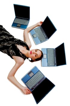 Beautiful woman lying near laptops and posing isolated over white
