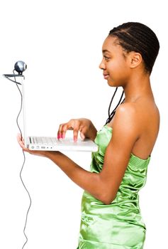 Teenage girl using a laptop and smiling isolated over white