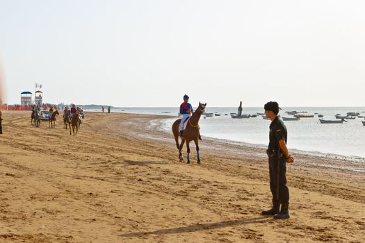 SANLUCAR DE BARRAMEDA, CADIZ, SPAIN - AUGUST 10: Unidentified riders at the start of race horses on Sanlucar de Barrameda beach on August 10, 2011 in Sanlucar de Barrameda, Cadiz, Spain.