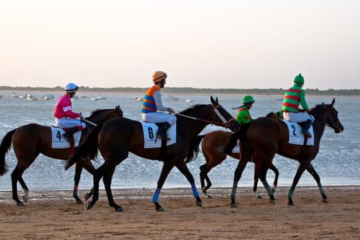 SANLUCAR DE BARRAMEDA, CADIZ, SPAIN - AUGUST 10: Unidentified riders at the start of race horses on Sanlucar de Barrameda beach on August 10, 2011 in Sanlucar de Barrameda, Cadiz, Spain.