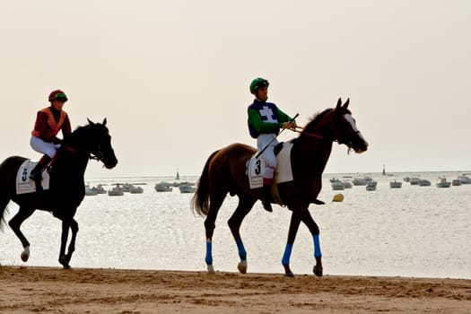 SANLUCAR DE BARRAMEDA, CADIZ, SPAIN - AUGUST 11: Unidentified riders at the start of race horses on Sanlucar de Barrameda beach on August 11, 2011 in Sanlucar de Barrameda, Cadiz, Spain.