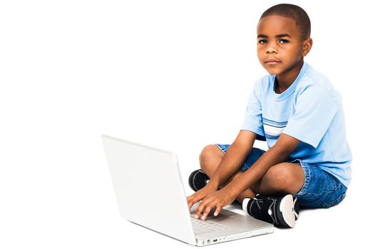 Portrait of a boy working on a laptop isolated over white