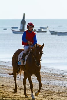 SANLUCAR DE BARRAMEDA, CADIZ, SPAIN - AUGUST 10: Unidentified rider at the start of race horses on Sanlucar de Barrameda beach on August 10, 2011 in Sanlucar de Barrameda, Cadiz, Spain.