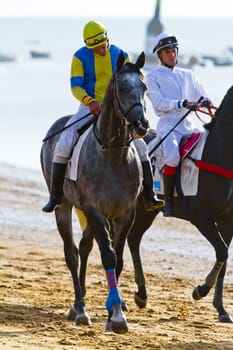 SANLUCAR DE BARRAMEDA, CADIZ, SPAIN - AUGUST 10: Unidentified riders at the start of race horses on Sanlucar de Barrameda beach on August 10, 2011 in Sanlucar de Barrameda, Cadiz, Spain.