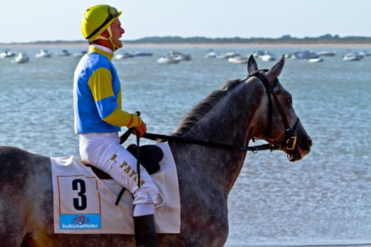 SANLUCAR DE BARRAMEDA, CADIZ, SPAIN - AUGUST 10: Unidentified rider at the start of race horses on Sanlucar de Barrameda beach on August 10, 2011 in Sanlucar de Barrameda, Cadiz, Spain.