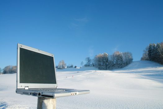 Laptop in a snowy winter landscape scene