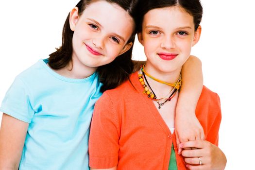 Portrait of two cute girls posing and smiling isolated over white