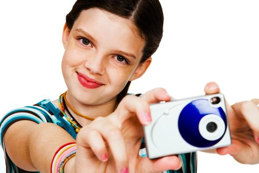 Smiling girl holding a camera and photographing isolated over white